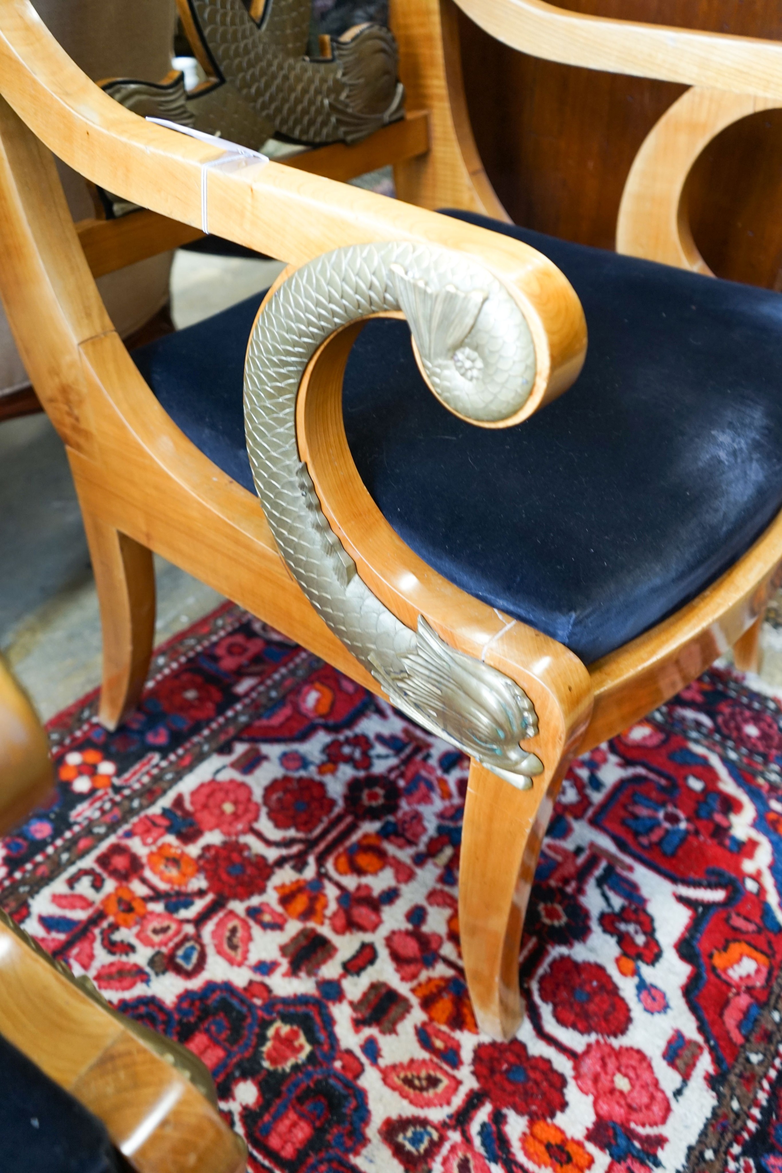 A pair of Empire style cherry elbow chairs with gilt metal dolphin mounts, width 65cm, depth 56cm, height 107cm